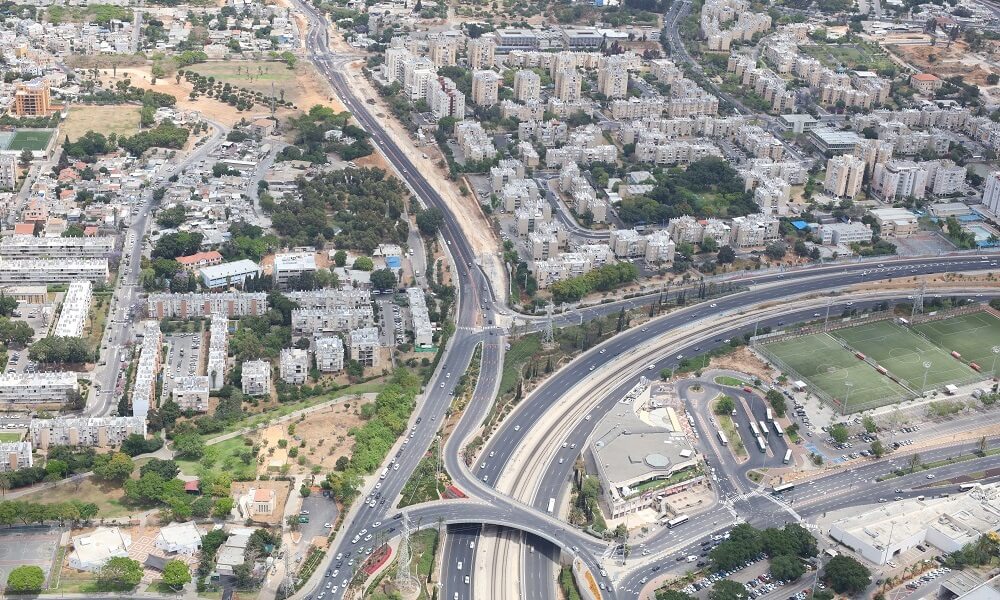 כביש ציר שלבים מלמעלה, מסביבו מלא בניינים ועצים